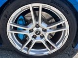 un gros plan sur un pneu d'une voiture de sport bleue