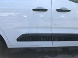 the side view of a white van with black trims parked in a parking lot
