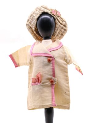 une poupée qui porte un chapeau et une robe