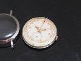 a silver pocket watch and a silver pocket watch on a black surface