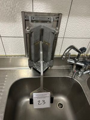 a stainless steel sink in a public restroom with a sign attached to it