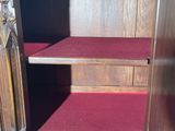 an image of a wooden cabinet with red carpet