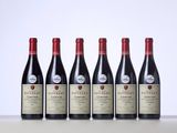 five bottles of red wine lined up in a row