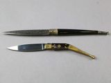 two different types of knives on a white surface