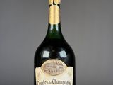 a bottle of champagne on a table with a glass of wine in front of it