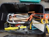 many tools in a black container on the ground