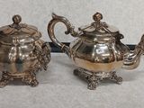 deux théières en argent posées l'une à côté de l'autre sur une table
