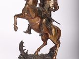 statue en bronze représentant un homme à cheval, avec un fusil sur le dos