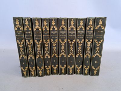 un lot de six livres noirs ornés de motifs dorés