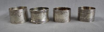four silver napkins with designs on them sitting on a table