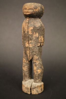 une statue en bois d'un homme avec un chapeau sur la tête
