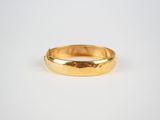 a gold wedding ring on a white background