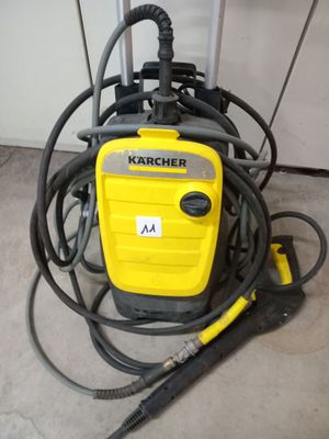 un aspirateur jaune et noir posé sur le sol, à côté d'un tas de tuyaux