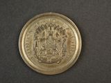 an old coin with a coat of arms on it on a black surface