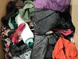 a cardboard box filled with clothes and clothing items