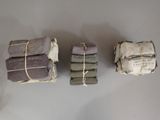 three stacks of folded books on a white table