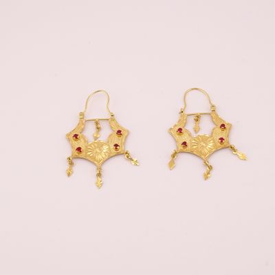 une paire de boucles d'oreilles en or ornées de pierres rouges