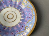 a blue and gold plate with a spiral design on it