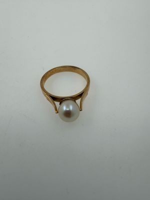 an image of a gold ring with a pearl on it