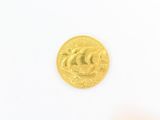 gros plan d'une pièce d'or sur une surface blanche