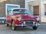 une voiture rouge et blanche garée devant un immeuble