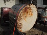 a man that is standing next to a large barrel