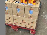 Des cartons de jus d'orange sont empilés sur une palette dans un entrepôt