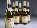 six bottles of wine are lined up in a row on a table