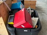 a bin full of boxes and a laptop on the floor