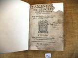 un livre ouvert sur lequel figure l'image d'un blason et un blason