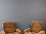 deux chaises marron placées devant un mur gris dans une pièce