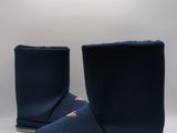 une paire de bottes bleues posées sur une surface blanche, avec une lumière en arrière-plan