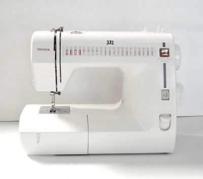 une machine à coudre blanche posée sur une surface blanche