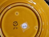 someone is holding a yellow plate with a sticker on it