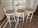 three white stools sitting in a kitchen next to a counter