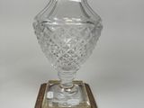 un vase en verre avec un bord doré sur une base carrée