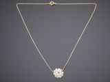 a gold necklace with a pearl flower on a chain