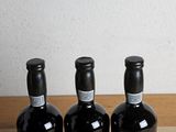 three bottles of wine sitting on a table next to each other