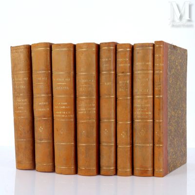several old books are stacked on top of each other on a white surface