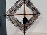 une sculpture représentant un objet noir posé sur une table blanche