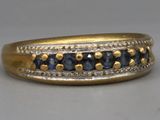 gros plan d'une bague en or avec des saphirs bleus