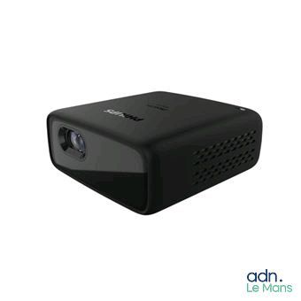 une image représentant un petit projecteur noir posé sur une surface blanche