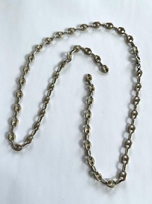 une image représentant une chaîne en argent ornée d'un cœur, posée sur un fond blanc