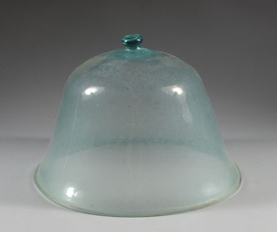 a glass dome with a green lid on a white table