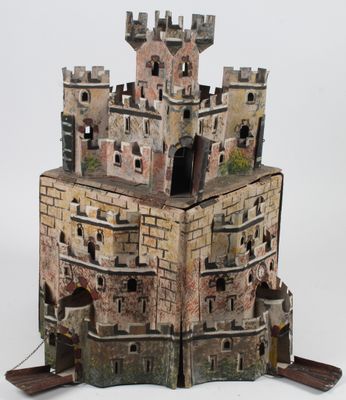 une petite maquette de château posée sur une surface blanche