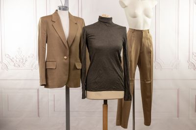 two mannequins and a suit on display in a room