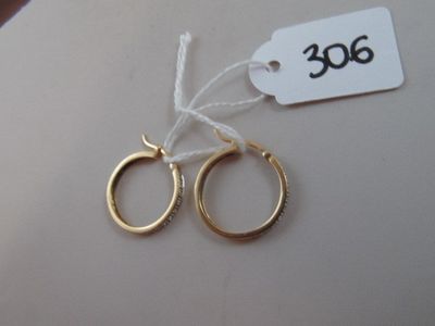 two pairs of gold hoop earrings with a price tag on them