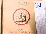 un livre posé sur un lit, à côté d'une feuille de papier