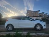 a white car parked in front of a building with a sky background