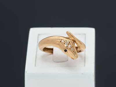 une image représentant une bague en or avec un diamant noir au centre